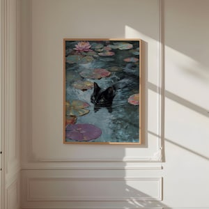 May include: A framed art print depicts a black cat swimming in a pond with lily pads and a pink water lily. The artwork has a vintage aesthetic, with muted colors and a focus on nature. The cat's eyes are visible.