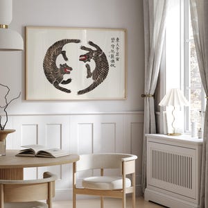 May include: A black and white print of two tigers facing each other in a circle. The print is framed and hanging on a white wall. The text in the image reads "學而不思則罔 思而不學則殆".