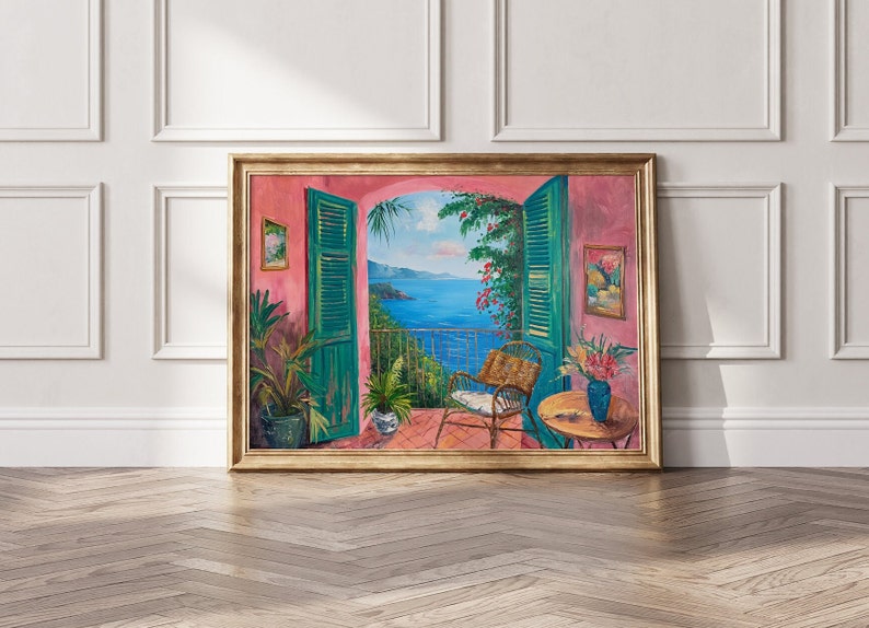 May include: A painting of a balcony overlooking a blue ocean with a green door and a wicker chair. The balcony is decorated with plants and flowers. The painting is framed in gold.