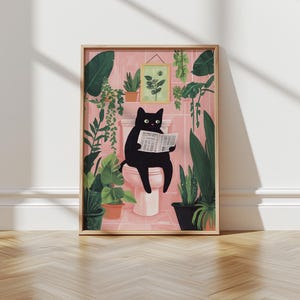 May include: A black cat sitting on a pink toilet reading a newspaper in a bathroom with green plants. The bathroom walls are pink and the floor is white.