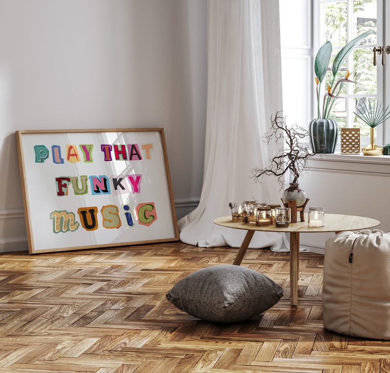 Puede incluir: Una impresi&oacute;n enmarcada con el texto "PLAY THAT FUNKY MUSIC" en letras coloridas y juguetonas. La impresi&oacute;n est&aacute; colgada en una pared blanca sobre un suelo de madera con un patr&oacute;n de espiga.