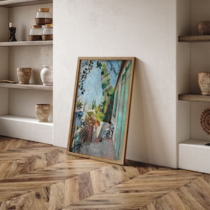 May include: A framed painting of a colorful landscape with a building and trees. The painting is in a wooden frame and is hanging on a white wall.