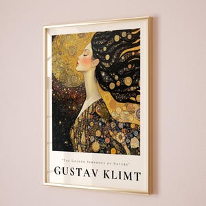 May include: A framed print of a painting by Gustav Klimt, featuring a woman with flowing black hair adorned with gold and black swirls. The background is a swirling pattern of gold and black, with the text "The Golden Symphony of Nature" at the bottom.