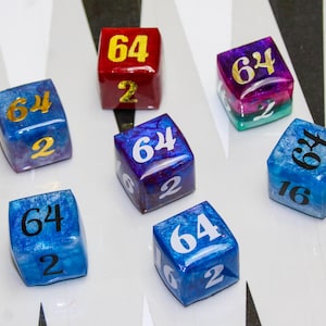 May include: Seven colorful dice with the numbers 64, 2, and 16. The dice are various colors, including red, blue, purple, and green, with gold or white numbering. The dice are on a white surface.
