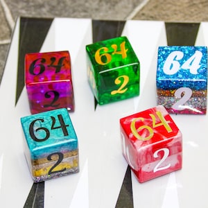 May include: Five colorful dice with the numbers 64 and 2 on each face. The dice are various colors, including red, green, blue, and purple, and are set on a black and white game board.