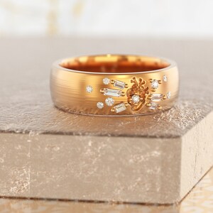 May include: A gold band ring with a heart design and small diamonds set in the band.