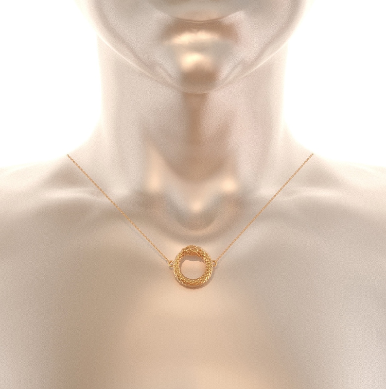 May include: A gold necklace with a circular pendant. The pendant is made of woven gold and has a smooth, polished finish.