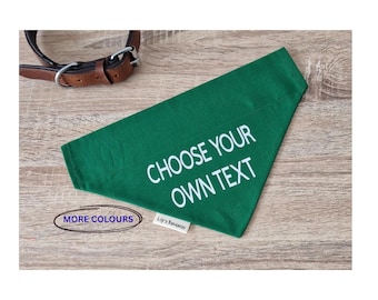 May include: A triangular green pet bandana featuring the white text CHOOSE YOUR OWN TEXT, accompanied by a brown leather collar with a metal buckle. A small white fabric tag reads Lily's Bandanas, and an oval graphic says MORE COLOURS.