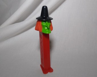 Vintage Witch Pez Candy Dispenser, standard size 1990, features green face witch with black hat and red "feet."