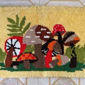 May include: A yellow rug with a mushroom and fern design. The mushrooms are red, orange, brown, and white. The ferns are green.