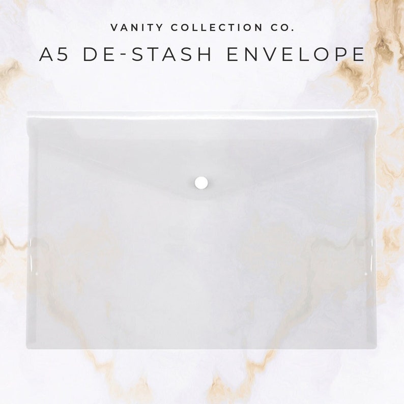 May include: A5 De-Stash Envelope by Vanity Collection Co. A translucent white plastic envelope with a snap closure. The envelope is rectangular and has rounded corners. The background has a marble pattern.