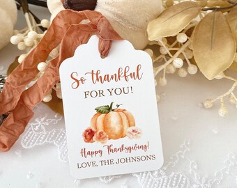 May include: A white gift tag with a watercolor illustration of a pumpkin and flowers. The text reads "So thankful for you! Happy Thanksgiving! Love, The Johnsons".