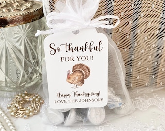 May include: A white rectangular gift tag tied to a sheer white organza drawstring bag filled with silver-wrapped candies. The tag features a brown turkey illustration and the text: So thankful FOR YOU! Happy Thanksgiving! LOVE, THE JOHNSONS.
