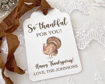 May include: White gift tag with brown text that reads "So thankful for you! Happy Thanksgiving! Love, The Johnsons". A watercolor illustration of a brown turkey is in the center of the tag.