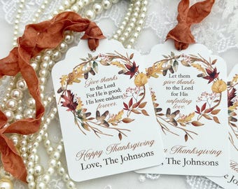 May include: White rectangular gift tags with rounded corners and rust-colored ribbon ties. Each tag features a watercolor wreath of autumn leaves, acorns, and berries. Text reads: Give thanks to the Lord, Happy Thanksgiving, Love, The Johnsons.