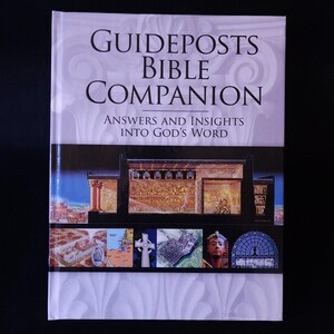 Peut inclure: Un livre à couverture rigide intitulé "Guideposts Bible Companion" avec le sous-titre "Answers and Insights Into God's Word". La couverture présente des illustrations architecturales et un portrait de pharaon, sur fond blanc et noir.