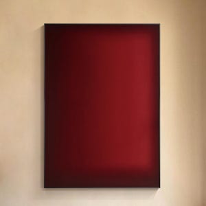 May include: A large rectangular wall art piece featuring a deep red gradient colour field. The artwork is displayed above a long cream-coloured sectional sofa with matching cushions, a dark wooden coffee table, and a black table lamp.