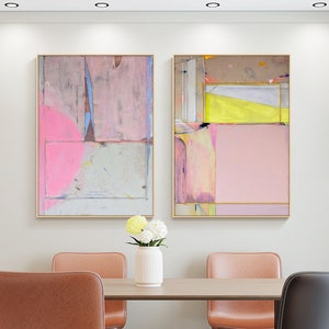 May include: Two abstract paintings with gold frames hang above a dining table. The artwork features pink, yellow, and blue hues. The dining set includes a wooden table, leather chairs, and a white vase with flowers.