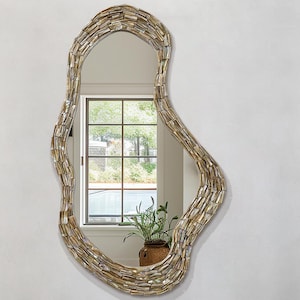 May include: An organic-shaped mirror with a mosaic frame hangs above a white, round sink. The sink is on a marble countertop with a small, round mirror and toiletries. Two white towels are neatly folded below the countertop.