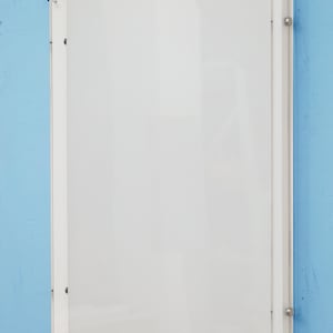 Peut inclure: Un cadre photo en acrylique transparent avec un passe-partout blanc. Le cadre est accroché à un mur bleu clair.