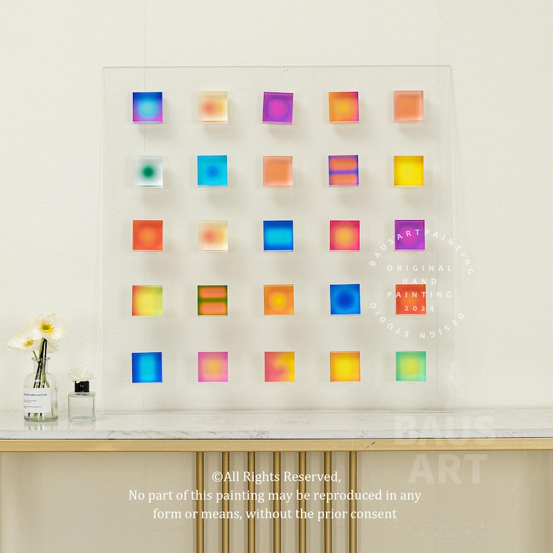 May include: A colorful abstract painting with a grid of 24 squares, each filled with a gradient of color. The painting is framed in a clear acrylic frame and has a circular stamp in the lower right corner that reads "Original Art Painting 2021".