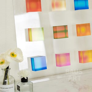 May include: A wall display of colorful, translucent acrylic blocks. The blocks are arranged in a grid pattern and are illuminated from behind, creating a vibrant and dynamic display.