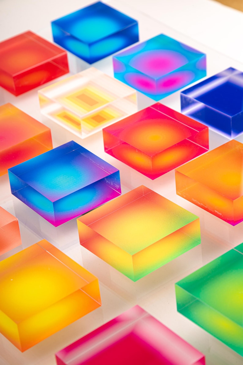 Puede incluir: Una serie de bloques cuadrados transl&uacute;cidos y coloridos en tonos rojo, naranja, amarillo, verde, azul y rosa. Los bloques parecen estar hechos de resina o un material similar, con un efecto degradado.