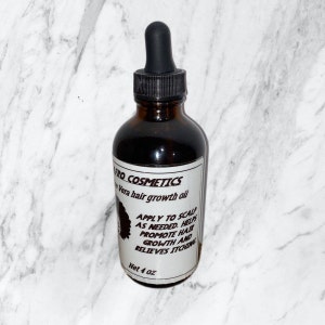 Puede incluir: Una botella de vidrio marr&oacute;n con un gotero, etiquetada "PRO COSMETICS Aloe Vera hair growth oil". La etiqueta tambi&eacute;n incluye instrucciones de uso: "APPLY TO SCALP AS NEEDED. HELPS PROMOTE HAIR GROWTH AND RELIEVES ITCHING". La botella contiene 4 onzas de aceite.