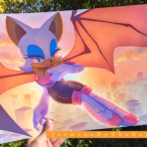 Puede incluir: Una impresión que presenta un personaje de murciélago de dibujos animados con pelaje blanco, ojos azules y grandes alas naranjas, sobre un fondo de paisaje urbano. El personaje sostiene un objeto marrón. El texto "JasmineByTheBay" está en la parte inferior.