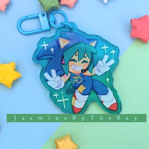 May include: A blue and green character with a blue and white striped shirt and a blue headband. The character is holding a peace sign with both hands. The character is on a clear blue background with white stars.