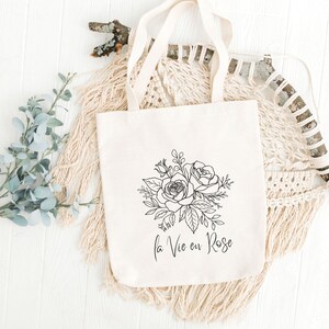 A white tote bag with roses and text la vie en rose