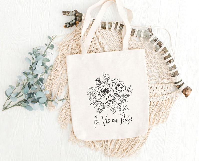 A white tote bag with roses and text la vie en rose