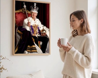 May include: A framed portrait of a person wearing a crown, holding a scepter and orb, seated on a throne. The portrait is in a wooden frame and hangs on a white wall. A person is holding a white mug in front of the portrait.