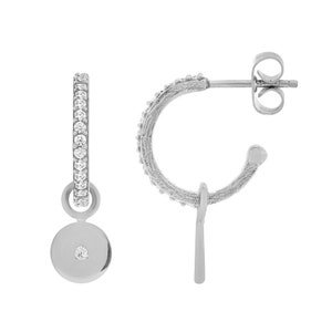 May include: Silver hoop earrings with a small circle charm dangling from one earring. The hoop is set with small clear stones.