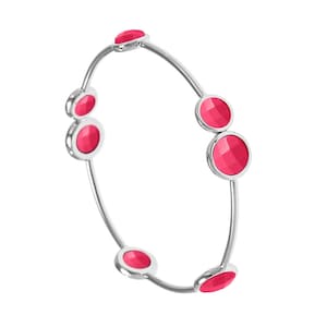 May include: A silver bangle bracelet with six pink round stones. The stones are set in the metal and have a faceted design.