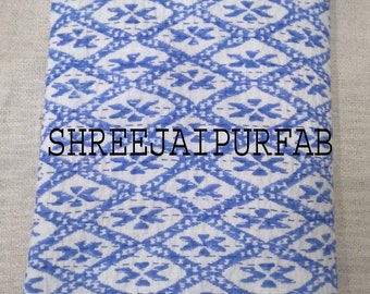 May include: A white and blue kantha quilt with a geometric pattern. The quilt is folded in half and has the text "SHREEJAI PURFAB" printed on it.