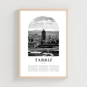 May include: Black and white framed print of Tabriz, Iran, featuring a cityscape under an arched design. The print includes the city's name and country, with a light wood frame.