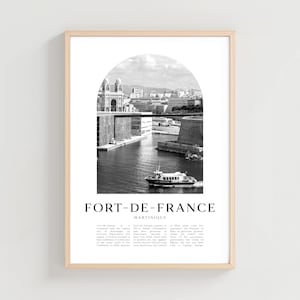 May include: Black and white framed print featuring a scenic view of Fort-de-France, Martinique. The image shows a harbor with a boat, buildings, and a bridge, framed by an arch. The text "FORT-DE-FRANCE" is at the bottom.
