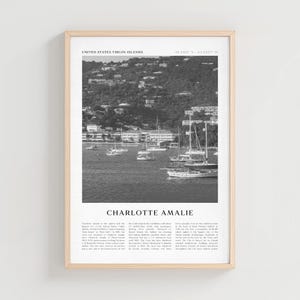 May include: Black and white framed print of Charlotte Amalie, United States Virgin Islands. The image features sailboats in the harbor, with a hillside in the background. The text "Charlotte Amalie" is at the bottom.