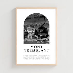 May include: Black and white framed print featuring a gondola lift over Mont Tremblant, Canada. The image is set within an arch, with the text "MONT TREMBLANT CANADA" below. The print is in a light wood frame.
