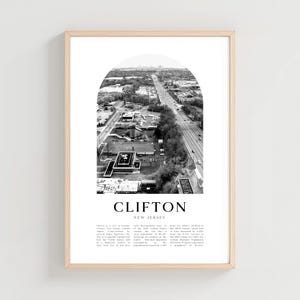 Puede incluir: Fotografía aérea en blanco y negro de Clifton, Nueva Jersey, enmarcada en madera clara. La imagen, dentro de un arco, muestra una autopista, edificios y un paisaje urbano distante. La palabra "CLIFTON" está centrada debajo de la imagen, con "NEW JERSEY" debajo.