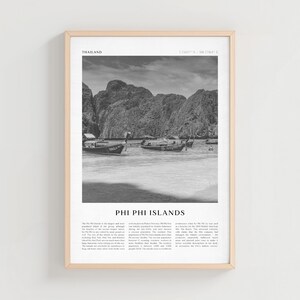 May include: Black and white framed print of the Phi Phi Islands in Thailand. The image shows boats on the water with large rock formations in the background. The text "PHI PHI ISLANDS" is at the bottom of the print.