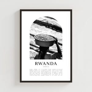 Puede incluir: Impresión enmarcada en blanco y negro que muestra a una persona llevando un cuenco de granos de café sobre la cabeza. La palabra "RWANDA" está impresa debajo de la imagen, con "AFRICA" debajo. La impresión incluye texto descriptivo sobre Ruanda.