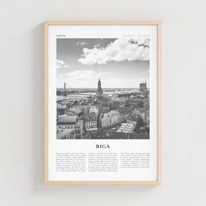 Puede incluir: Impresión enmarcada en blanco y negro de Riga, Letonia. La imagen presenta un paisaje urbano con un río, un puente y edificios. La palabra "RIGA" está impresa en letras grandes debajo de la imagen, con texto que describe la ciudad.