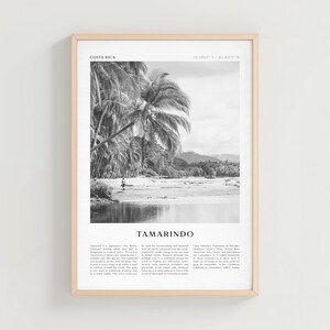 Può includere: Stampa incorniciata in bianco e nero con una scena di spiaggia con palme e una persona che cammina sulla riva. La stampa include il testo "COSTA RICA" e "TAMARINDO". La cornice è di colore legno chiaro.