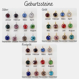 May include: A selection of birthstone pendants in silver, gold, and rose gold. Each pendant has a round, coloured gemstone, with months of the year labelled below. The German text "Geburtssteine" is at the top.