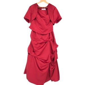 May include: A formal red dress with a matching bolero jacket. The dress features a fitted bodice with beaded embellishments and a draped skirt. The bolero has short sleeves. The outfit is displayed on a wooden hanger.