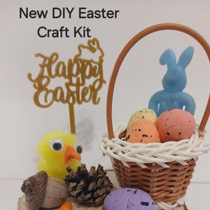 May include: A DIY Easter craft kit with a wicker basket filled with colorful speckled eggs, a blue bunny, and a golden "Happy Easter" sign. A yellow chick with googly eyes and a pine cone are also included.