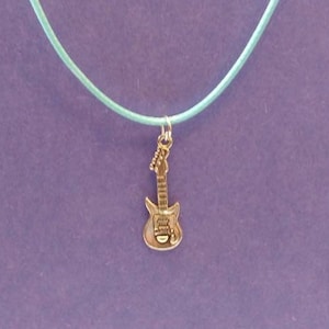 Op de afbeelding: Een zilveren elektrische gitaar bedel aan een lichtblauwe koord ketting.