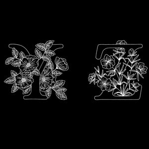 May include: A black and white line drawing of the letters Y and Z with floral designs. The letters are surrounded by flowers and leaves.